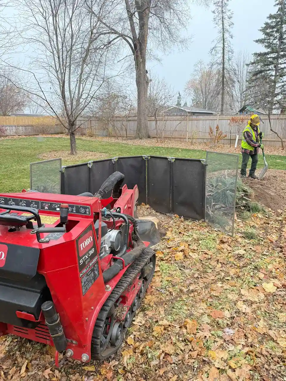 Stump grinder in action with protective barrier in Twin Cities